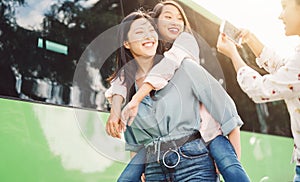 Happy Asian girls having fun outdoor - Millennial young people sharing time together and using mobile smartphone new trendy apps