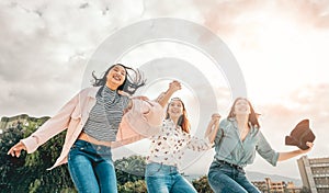 Happy Asian girls jumping outdoor - Young women friends having fun during university break