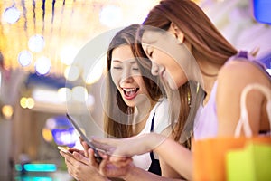 Happy girls watching phone in the shopping mall