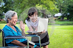 Šťastný asijský vnučka požívat a babička konference přenosný počítač počítač s 
