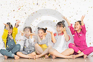 Happy Asian group of kids having fun during birthday party with confetti