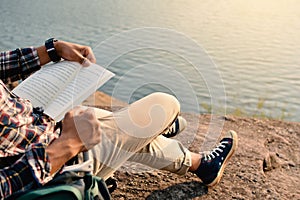 Happy Asian hipster man reading a book in nature background