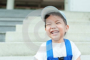 Happy Asian Japanese boy in backpack and blue cap