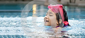 Happy asian kid big smile to playing swim in water pool