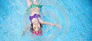 Happy asian kid big smile to playing swim in water pool