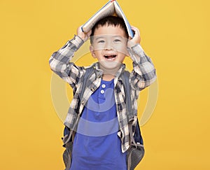 Happy asian kid  holding book above his head