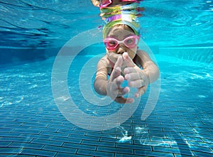 Happy asian kid swimming underwater in summer.