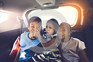 Happy Asian kids travelling in car.