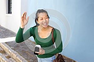 Happy asian lady outdoors on street gesturing for a taxi