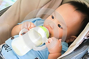 Happy Asian little baby sucking milk