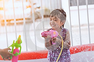 Happy asian little child girl having fun to play water
