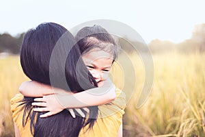 Happy asian little child girl hugging her mother with love