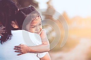 Happy asian little child girl hugging her mother with love