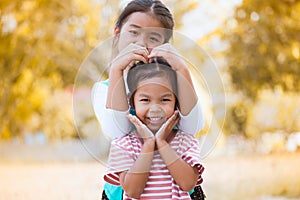 Happy asian little child girl making hand in heart shape