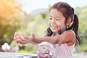 Happy asian little child girl showing her money