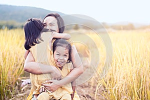 Happy asian little child girls hugging mother