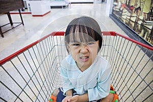 Happy Asian Little Chinese Girl sitting in shopping cart