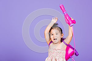 Happy Asian little girl holding plastic water gun