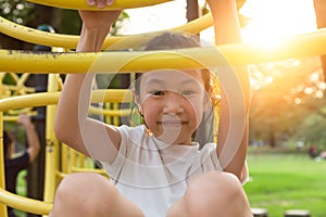 Happy,Asian little girl playing on a playground outdoor and looking at camera in the park,summer,vacation concept