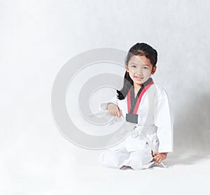 Happy Asian little girl smile sitting and tie a white line in ta