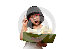 Happy Asian little preschool girl wearing red glasses holding a green book and thumbs up on white isolated background. Concept of