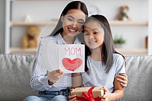 Happy asian loving daughter greeting mom with Mothers Day, young woman holding and reading handmade card