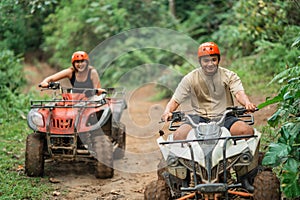 happy asian man fastly riding the atv through the atv track