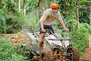 happy asian man smiling while riding the atv