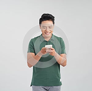 Happy asian man typing sms on white background