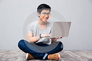 Happy asian man using laptop