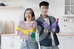 Happy asian man and woman house-keepers enjoying cleaning