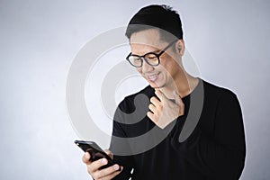 Happy asian men using smart phone and smiling at home.