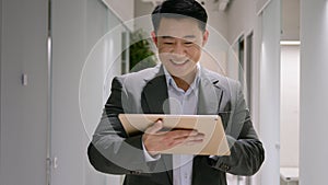 Happy Asian middle-aged ethnic man chinese korean businessman smiling business employer use digital tablet in office