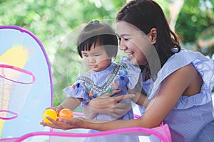 Happy asian mother and cute little baby girl playing together