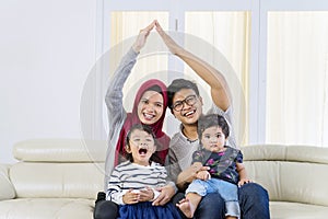Happy Asian muslim family doing heart symbol pose