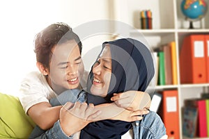 Happy Asian muslim mother hug her little boy, single mom and kid being happy family together, motherhood concept