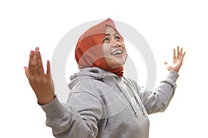 Happy Asian muslim woman shows happy surprised winning gesture greeting expecting something from above