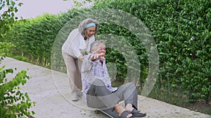 happy asian old couple having fun playing skateboard together in backyard at home. senior man riding skate and elder woman