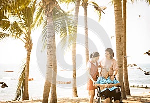 Happy asian old elderly relaxing enjoying a beautiful view by the sea beach on vacation,smiling senior woman with family strolling
