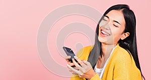 Happy Asian portrait beautiful cute young woman excited laughing holding mobile phone