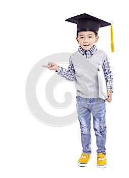 Happy Asian school kid graduate in graduation cap and hand pointing to copy space