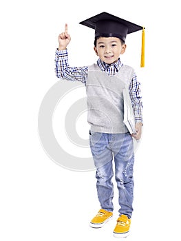 Happy Asian school kid graduate in graduation cap and hand pointing up
