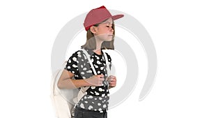 Happy Asian schoolgirl with backpack walking on white background.