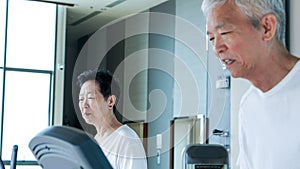 Happy Asian senior couple running on treadmill healthy lifestyle