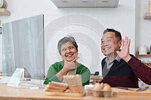 Happy Asian senior couple talking with video calling in the room