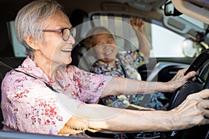 Happy asian senior female driver in her car,enjoy traveling during retirement age with her friend,healthy old people having fun,