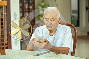 Happy asian senior man using the mobile phone