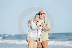 Happy Asian senior man and woman couple smile dancing resting relax on the beach