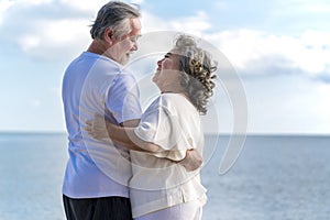 Happy asian senior retired couple relax smiling elder man and woman enjoying with retired vacation at sea beach outdoor. Health