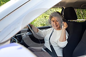 Happy Asian senior woman driver showing new car keys